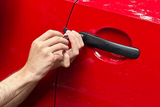 Beswick car locksmith lock picking a red car door