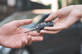 Locksmith handing over car keys to customer