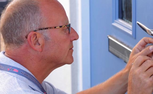 Locksmith gaining entry to door lock by picking