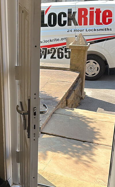 LockRite locksmith Josh showing an unlocked customer door after an emergency lockout with his LockRite van shown in the background