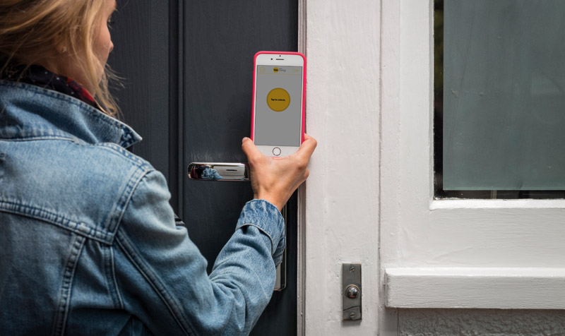 Homeowner unlocking Front Door With Yale Conexis L1 Smart Lock